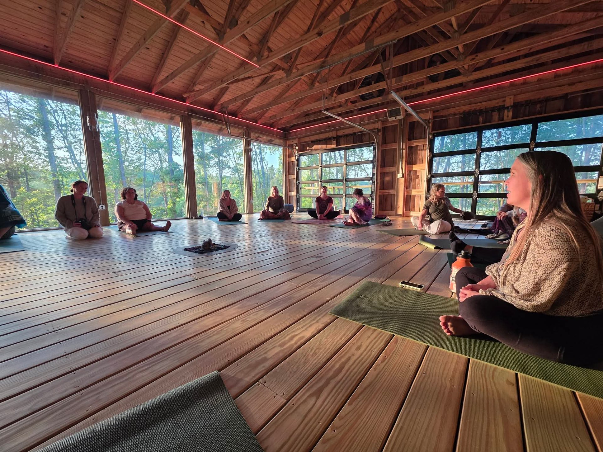 Women sitting in circle inside a sunlit barn sanctuary